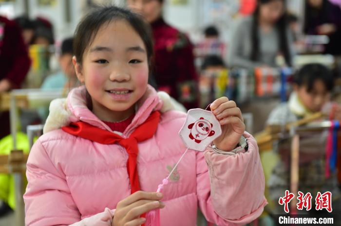 圖為一名小學(xué)生繡制的2022年北京冬奧會吉祥物“冰墩墩”形象?！∮髟屏?攝