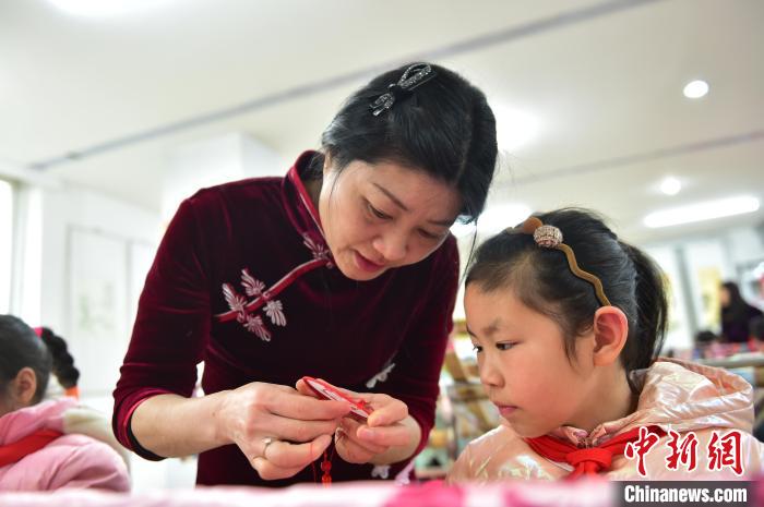 江西省級非遺豫章繡傳承人手把手指導(dǎo)小學(xué)生繡制2022年北京冬奧會吉祥物“冰墩墩”形象?！∮髟屏?攝