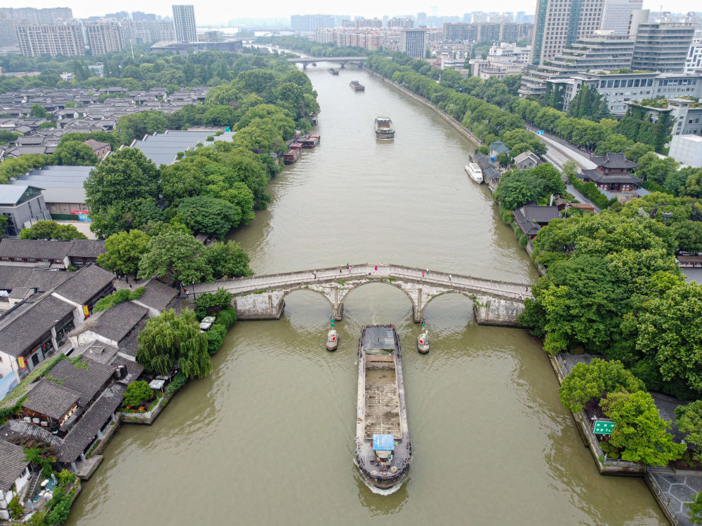 5月27日，一艘貨船駛過京杭大運(yùn)河南端標(biāo)志建筑杭州拱宸橋。(無人機(jī)照片)新華社記者江漢 攝