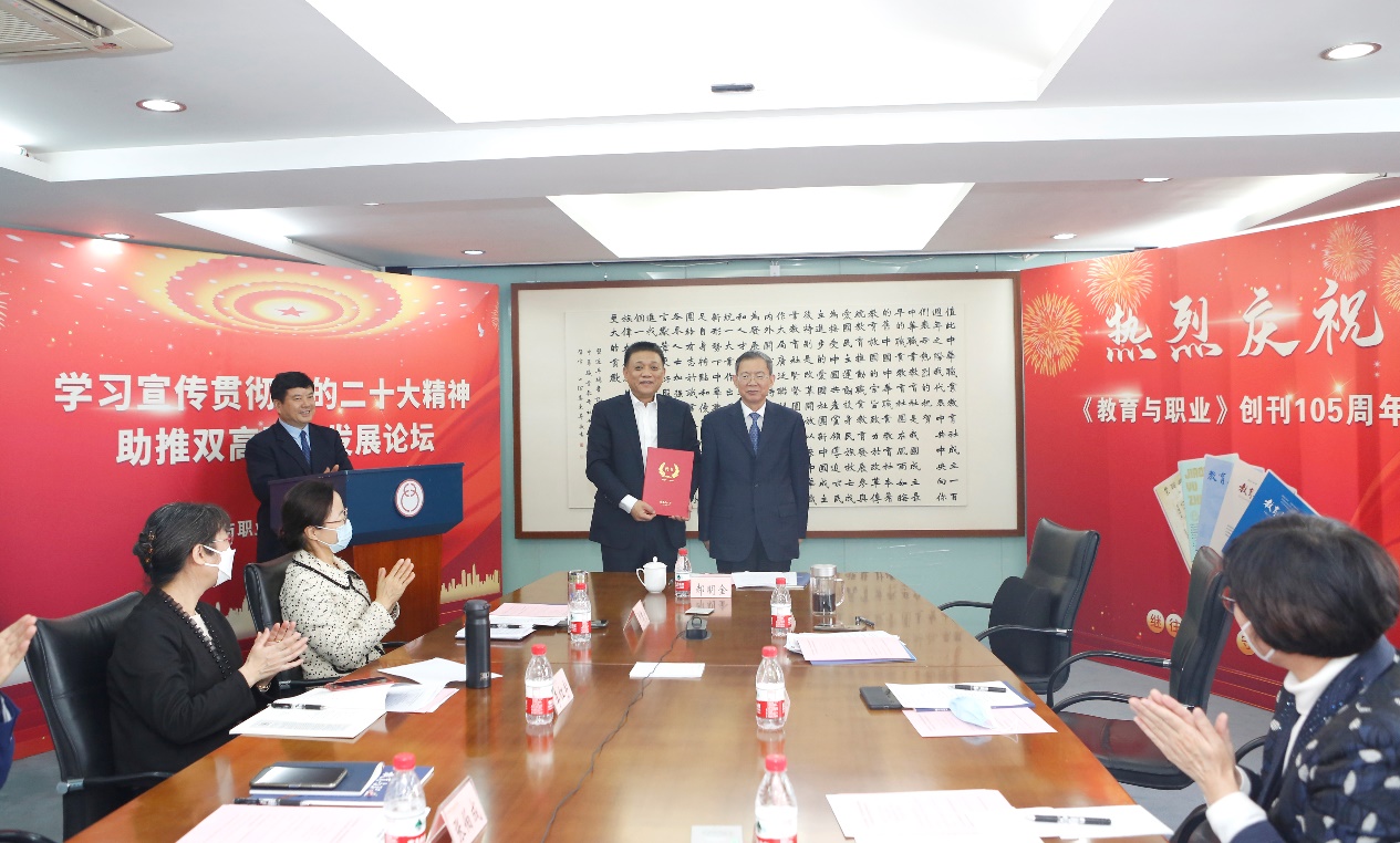 郝明金為《教育與職業(yè)》雜志編委代表陳曉明頒發(fā)聘書(shū)。中華職教社供圖