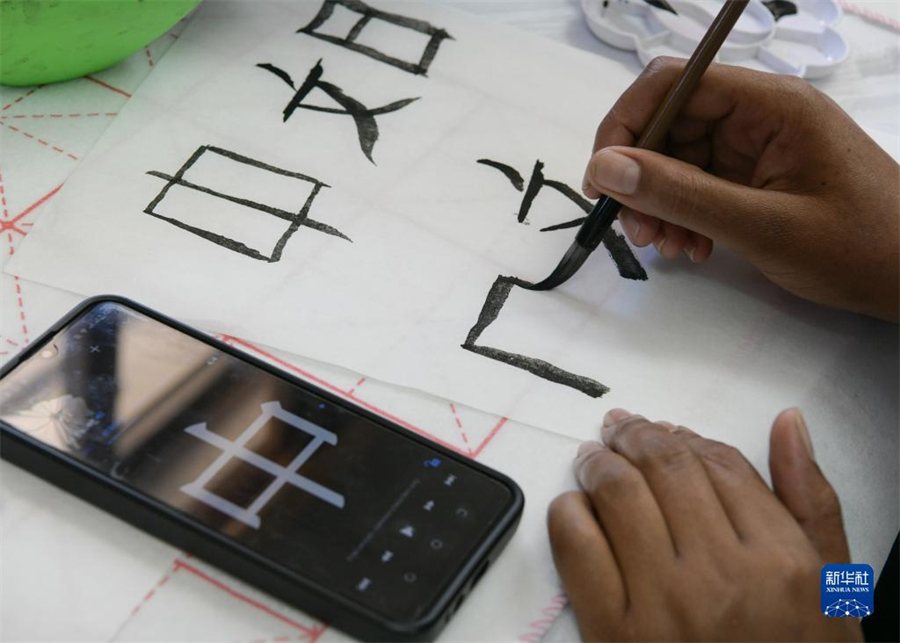 4月18日，肯尼亞學(xué)生在內(nèi)羅畢大學(xué)孔子學(xué)院舉辦的活動(dòng)上寫(xiě)毛筆字。肯尼亞內(nèi)羅畢大學(xué)孔子學(xué)院18日舉辦“中文，增進(jìn)文明對(duì)話”主題活動(dòng)，慶祝即將到來(lái)的第14個(gè)聯(lián)合國(guó)中文日?？夏醽唽W(xué)生參與互動(dòng)，進(jìn)行書(shū)法、剪紙、唱中文歌等活動(dòng)。新華社記者 韓旭 攝