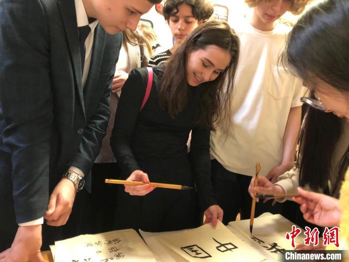 4月21日，莫斯科國立語言大學(xué)孔子學(xué)院附屬中學(xué)舉辦“國際中文日”活動，學(xué)生們學(xué)寫漢字?！∧箍茋⒄Z言大學(xué)孔子學(xué)院 供圖