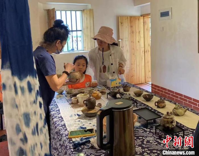 圖為：游客正在咨詢(xún)臺(tái)灣柴燒作品?！∪~秋云 攝