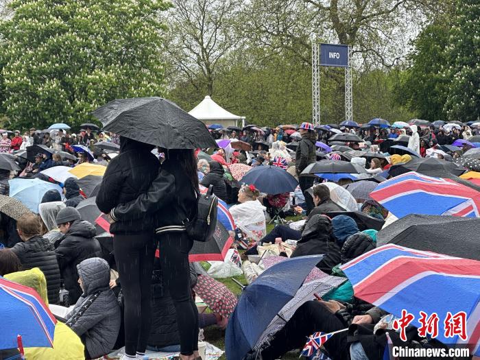 當(dāng)?shù)貢r(shí)間5月6日，英國國王查爾斯三世的加冕儀式舉行。民眾雨中觀看儀式。　歐陽開宇 攝