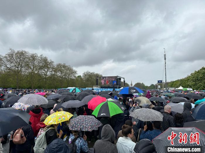當(dāng)?shù)貢r(shí)間5月6日，英國國王查爾斯三世的加冕儀式舉行。民眾雨中觀看儀式。　歐陽開宇 攝