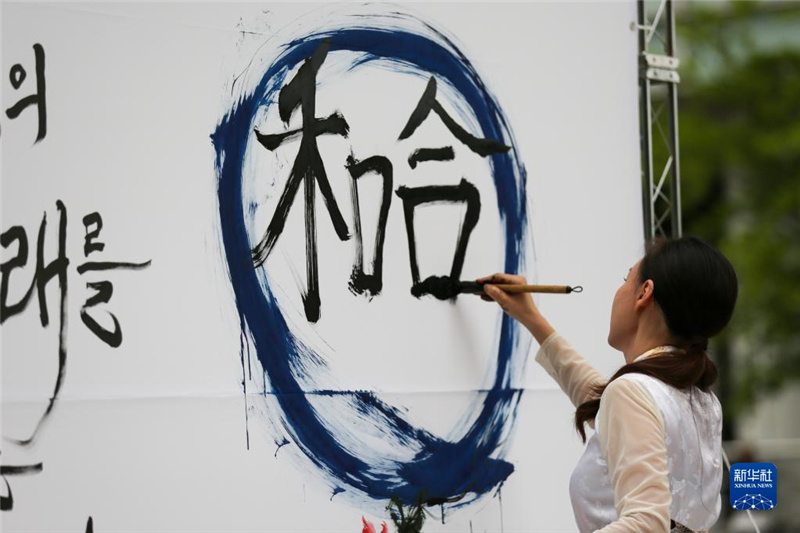 5月30日，在韓國首爾舉辦的“中日韓合作之日”慶?；顒又校硌菡哌M行中日韓精神——2023年度漢字“和合”書法表演。新華社記者 王益亮 攝