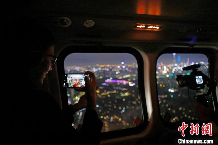 6月3日晚，游客乘坐上海新空直升機(jī)有限公司直升機(jī)開啟鳥瞰黃浦江空中圓夢之旅，并用手機(jī)拍攝城市夜景。　殷立勤 攝