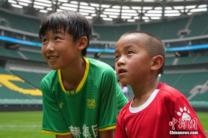 圖為北京國安小球員陳小北和7歲的俄金仁增在一起觀看場內(nèi)播放的紀(jì)錄片。<a target='_blank' href='/' _fcksavedurl='/'><p  align=
