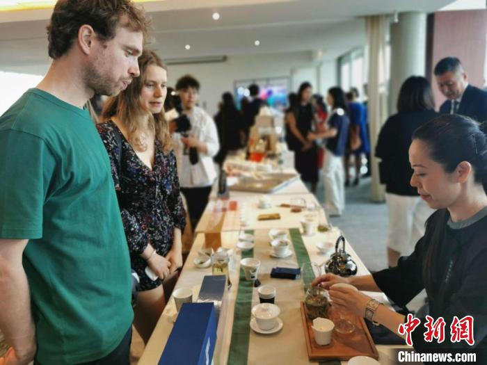 現(xiàn)場觀眾觀看中國展臺茶藝表演、了解茶文化。　靖樹 攝