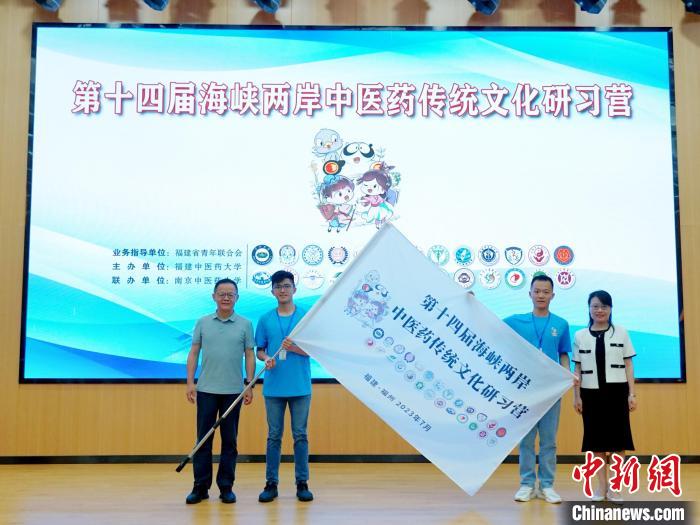 共青團福建省委副書記吳雪(右一)、福建中醫(yī)藥大學黨委副書記林羽(左一)為兩岸學生代表頒授營旗?！≡S燁婷 攝