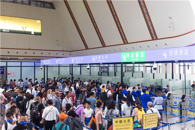 7月22日，乘坐中老鐵路國(guó)際旅客列車的旅客在磨憨邊檢大廳排隊(duì)候檢。衛(wèi)海林 攝