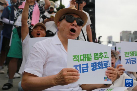 7月22日，在韓國(guó)首爾，人們手舉標(biāo)語(yǔ)參與反戰(zhàn)游行。新華社發(fā)（楊暢 攝）