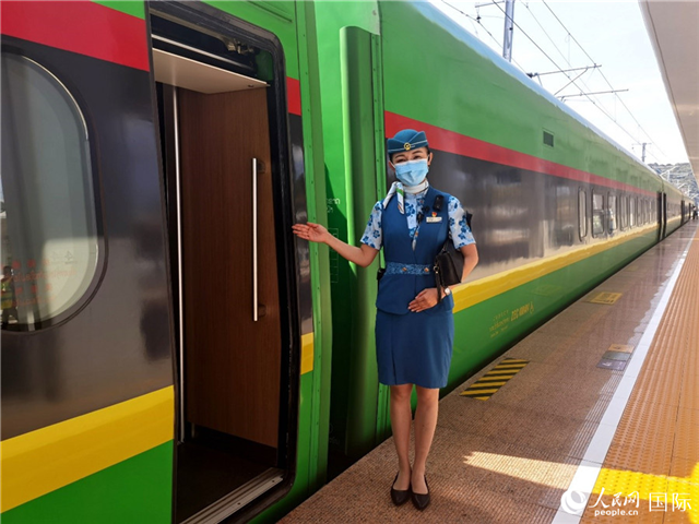 趙瑩靜站在“復(fù)興號”國際旅客列車車廂門口歡迎旅客上車。人民網(wǎng) 杜明明攝