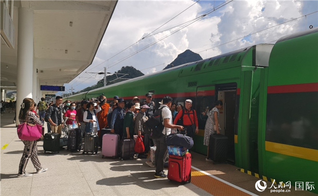 乘坐中老鐵路國際旅客列車的旅客在老撾瑯勃拉邦站排隊上車。人民網(wǎng)記者 杜明明攝
