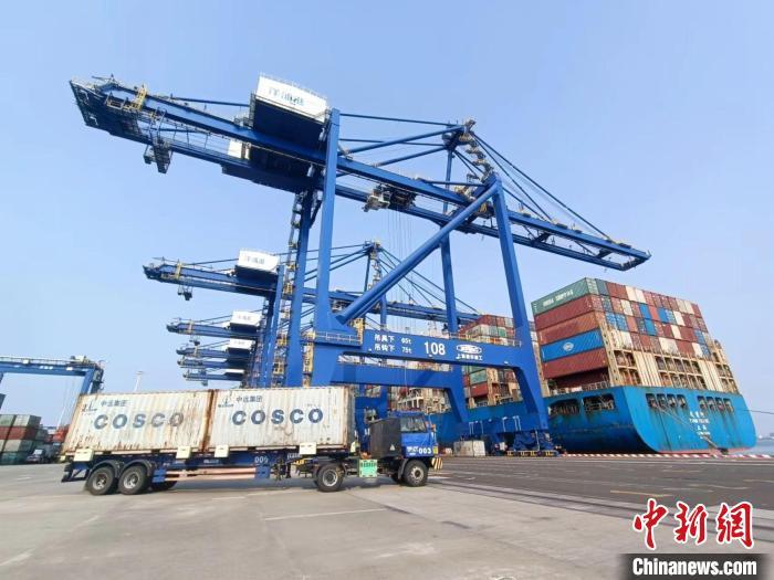 圖為海南洋浦國際集裝箱碼頭，卡車將集裝箱從后方堆場運往碼頭裝卸區(qū)。　張月和 攝