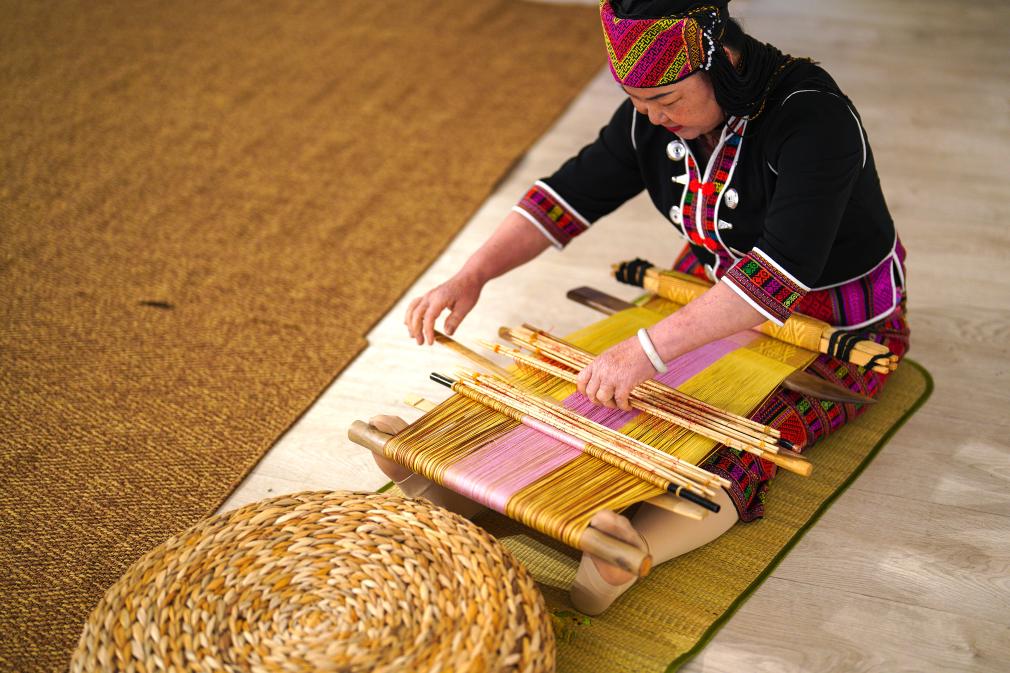 4月17日，黎族傳統(tǒng)紡染織繡技藝國(guó)家級(jí)代表性傳承人劉香蘭在2023年意大利米蘭設(shè)計(jì)周上展示黎錦織造技藝。新華社發(fā)