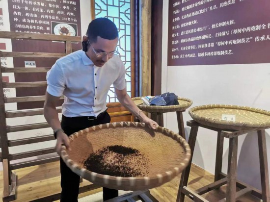 2023“一帶一路”媒體合作論壇聯(lián)合采訪團(tuán)團(tuán)員在非遺文化展示館體驗(yàn)中藥炮制技藝。（本報(bào)記者 黃超攝）