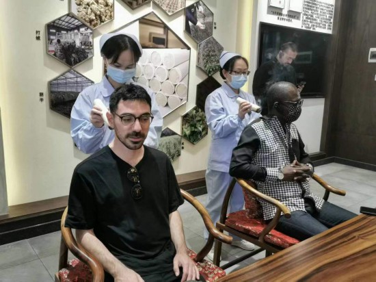 2023“一帶一路”媒體合作論壇聯(lián)合采訪團(tuán)團(tuán)員在九牛草展示館體驗(yàn)艾灸。（本報(bào)記者 黃超攝）