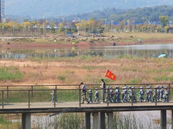 　　10月24日，秋游的幼兒園小朋友在老師帶領(lǐng)下走在清水塘公園里的木橋上。本報記者 常雯宜攝