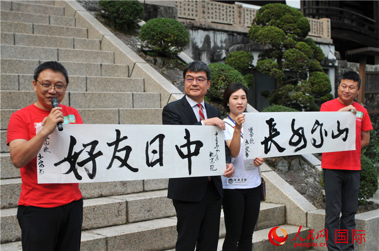 東京中國文化中心主任羅玉泉展示其為本次活動書寫的題詞“中日友好，山高水長”。人民網(wǎng) 蔣曉辰攝