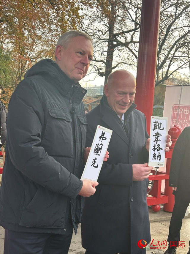 柏林市長韋格納（右）、動物園監(jiān)事會主席布魯克曼（左）手持中國文化中心工作人員現(xiàn)場手書的中文名字。人民網(wǎng)記者 徐馨攝