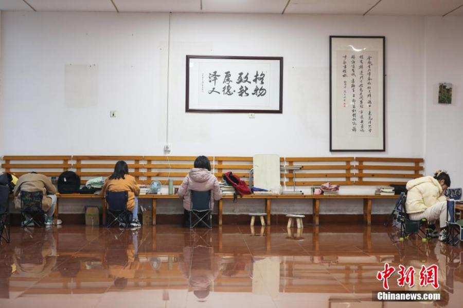 資料圖：幾位考研學(xué)生在南昌大學(xué)教學(xué)樓的公共空間復(fù)習(xí)備考。劉力鑫 攝
