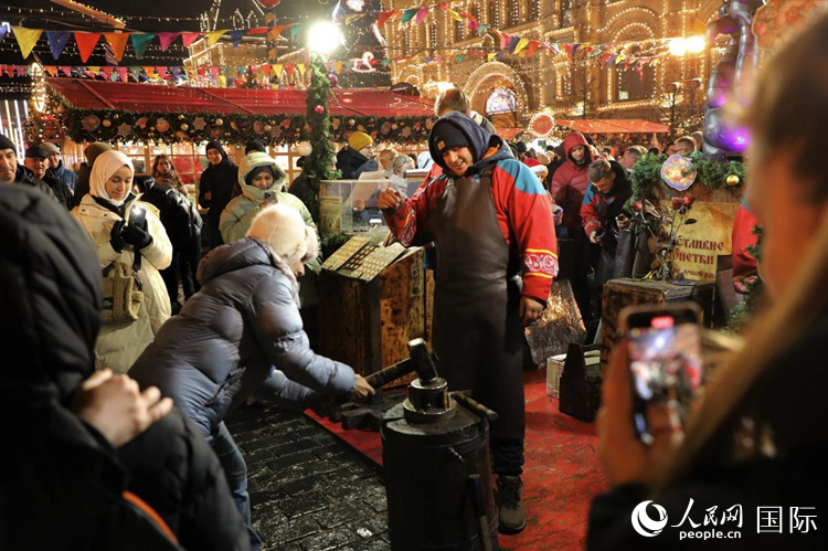 游客在新年集市上體驗制作紀念幣。人民網(wǎng)記者 隋鑫攝