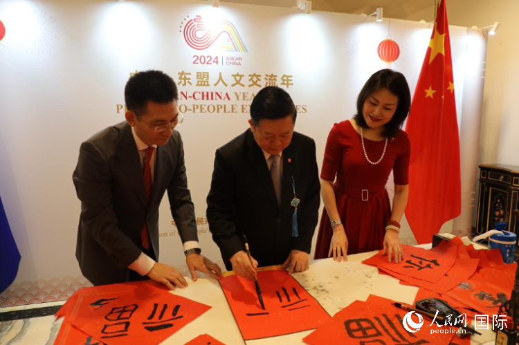 東盟秘書長高金洪（中）在活動現(xiàn)場寫福字。人民網(wǎng)記者曹師韻攝