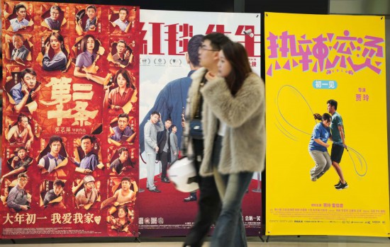這是2月17日，在沈陽一家影院，觀眾從海報(bào)前經(jīng)過。新華社記者李鋼攝