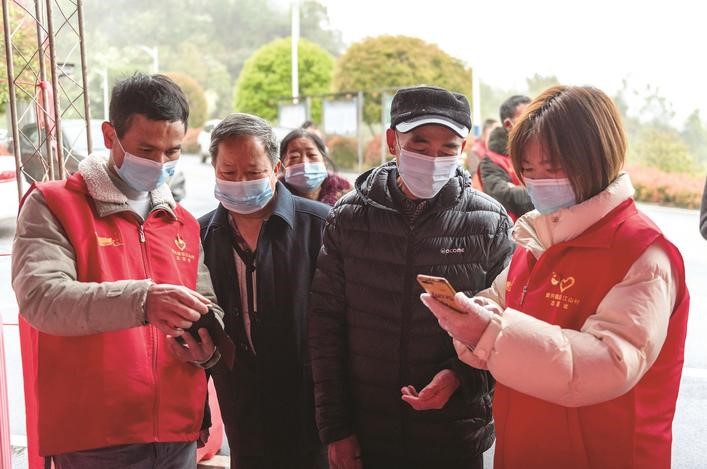 長沙縣黨員志愿者正在幫助參與核酸檢測的群眾掃描“場所碼”。劉思源 攝