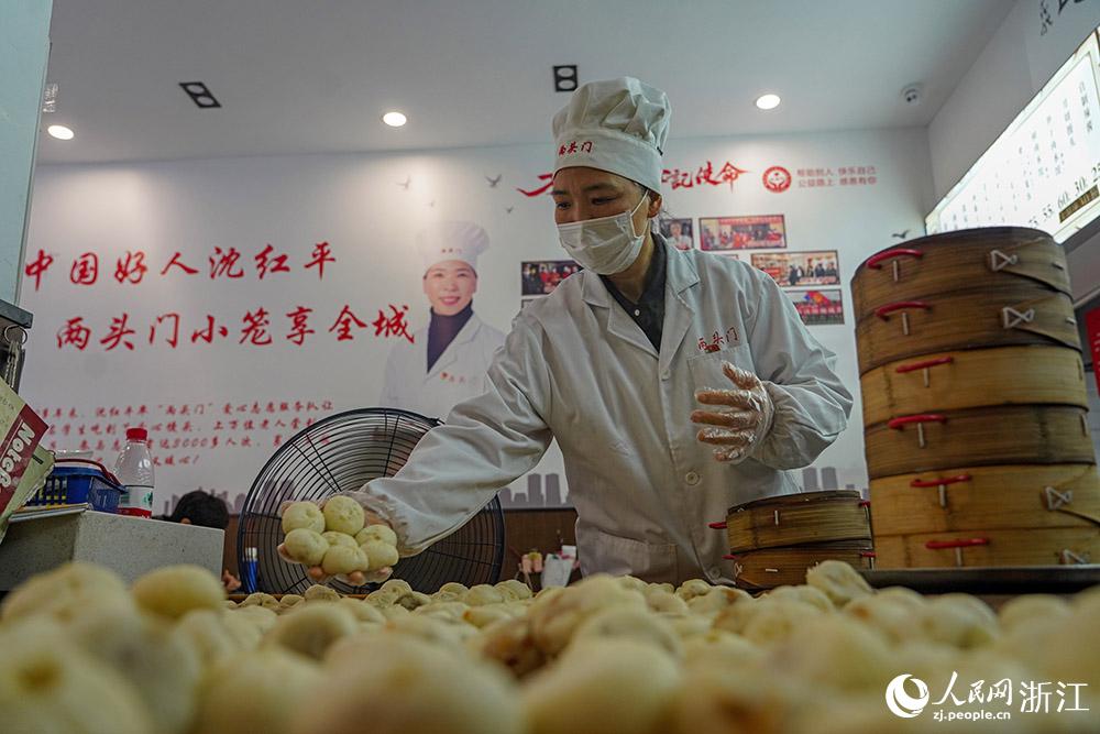 3月31日，在浙江省嵊州市甘霖鎮(zhèn)，嵊州小吃從業(yè)者沈紅平把蒸熟的小籠包晾涼，打包冷藏售賣。人民網(wǎng) 章勇濤攝