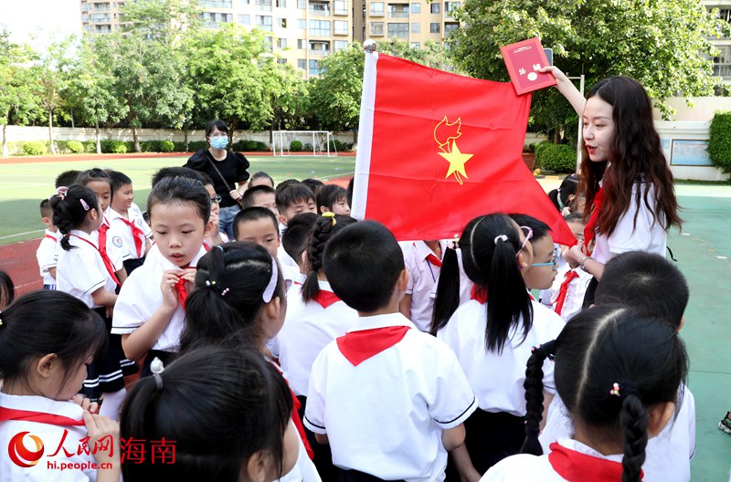 老師向少先隊員展示隊旗。人民網(wǎng) 符武平攝