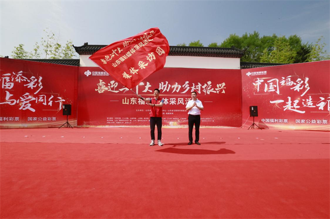 為媒體采風(fēng)團(tuán)授旗。 山東省福彩供圖