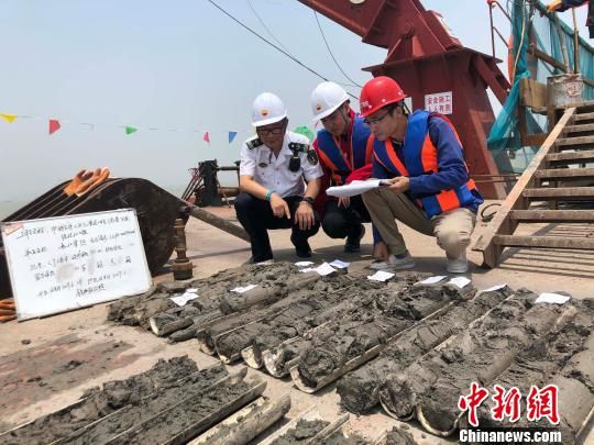 圖為勘察設(shè)計(jì)人員與海事局工作人員查看巖芯情況?！∥赫?攝