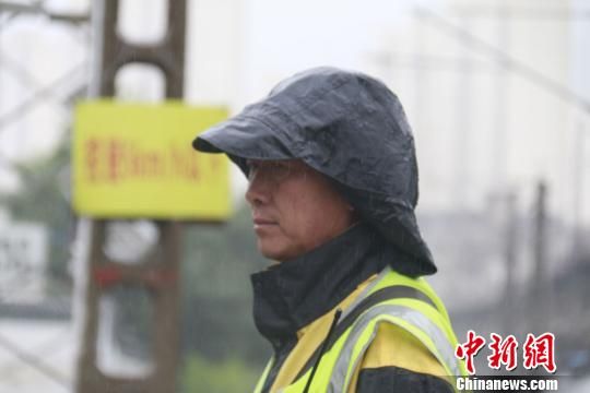 蘭州西工務(wù)段蘭州線路車間防護(hù)員雨中巡查?！⊥豕廨x 攝