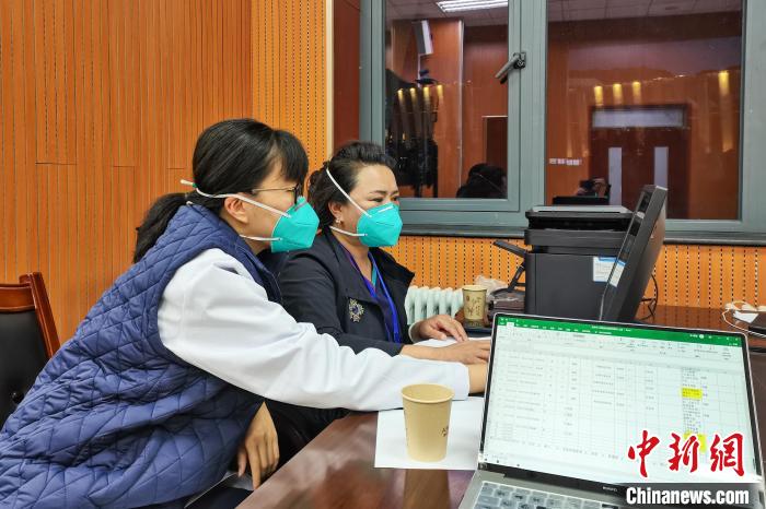 8月9日，楊蘇喬(左)在拉薩方艙醫(yī)院指揮部讀取艙內(nèi)患者胸部CT?！∈茉L者供圖