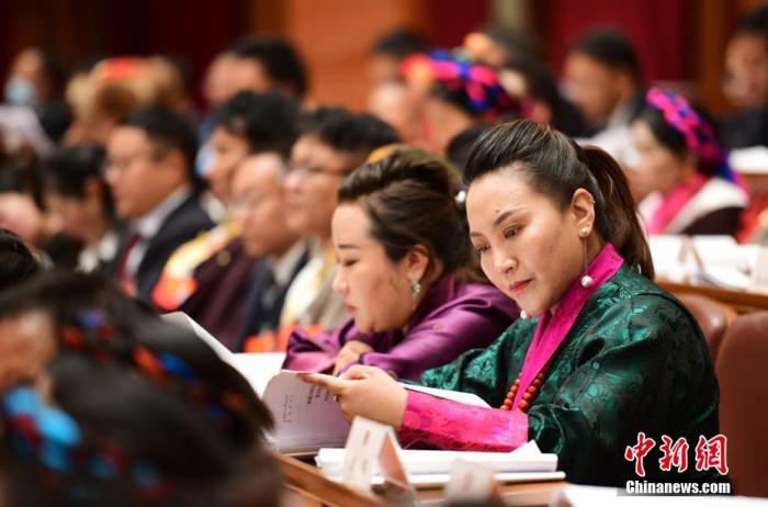 1月5日，次旦卓嘎(右一)在拉薩參加西藏自治區(qū)第十一屆人民代表大會第五次會議第二次全體會議。西藏自治區(qū)人大代表次旦卓嘎來自日喀則市定日縣，定日縣被稱為“洛諧故鄉(xiāng)”，作為西藏民間歌舞，洛諧已被列入中國國家非物質(zhì)文化遺產(chǎn)項(xiàng)目名錄，這是集歌、舞、樂、彈唱于一體的綜合藝術(shù)形式。參加完西藏2022年新年音樂會的次旦卓嘎告訴記者，每年參加的基層演出可達(dá)80場，“我希望用最純粹的方式，把最好的聲音帶到西藏乃至中國的各個(gè)角落?！?<a target='_blank' href='/'><p  align=