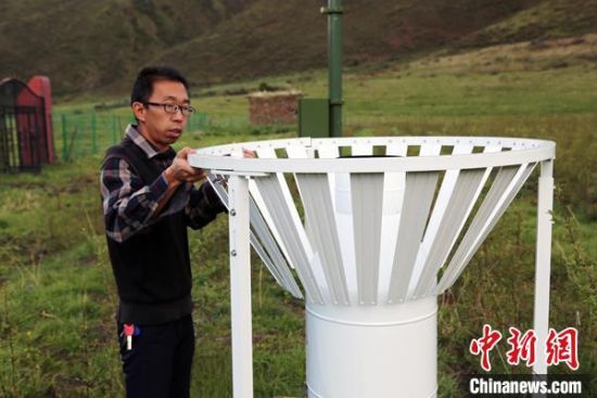 圖為班瑪縣氣象局工作人員在維護(hù)藏雪茶基地氣候站。青海省氣象局供圖
