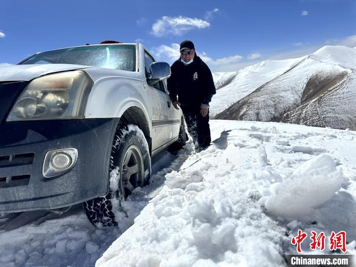 圖為生態(tài)管護人員準備在雪地推車?！《“瓦_杰 攝