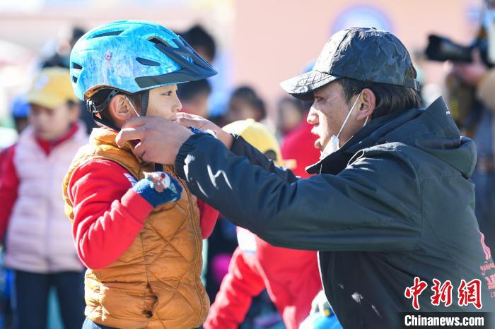 圖為拉薩市實(shí)驗(yàn)幼兒園孩子在教練的幫助下穿戴頭盔?！『闻罾?攝