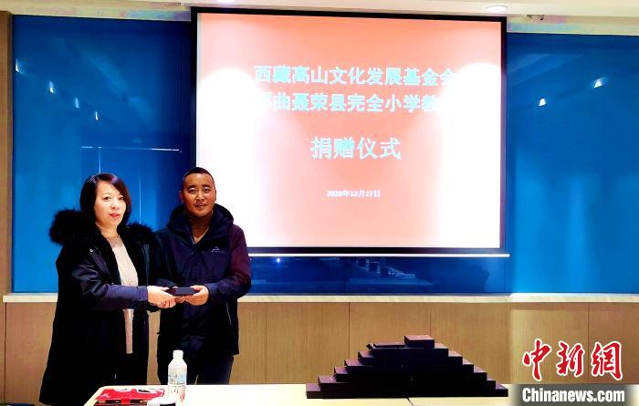 圖為西藏高山文化發(fā)展基金會(huì)理事長溫麗向聶榮縣完全小學(xué)負(fù)責(zé)人捐助儀器?！∮谫e 攝