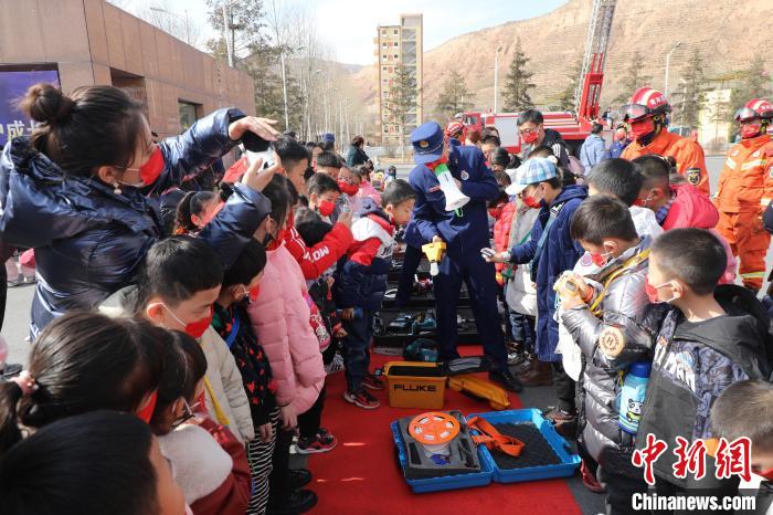圖為小朋友們聽消防員講解消防器材。　楊龍建 攝