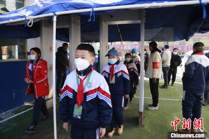 圖為學生測量體溫后進入校園?！●R銘言 攝
