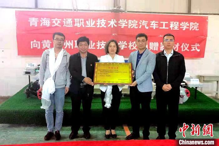 圖為李富香(中)代表學(xué)校為州縣技校捐贈(zèng)器材。(資料圖) 青海省教育廳供圖