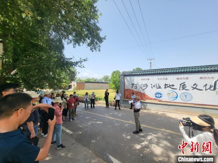 圖為中國地質(zhì)大學(北京)教授張緒教介紹村落情況?！『衍?攝