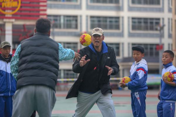 在高原上教孩子們打手球，“慢慢兒來，甭著急！”