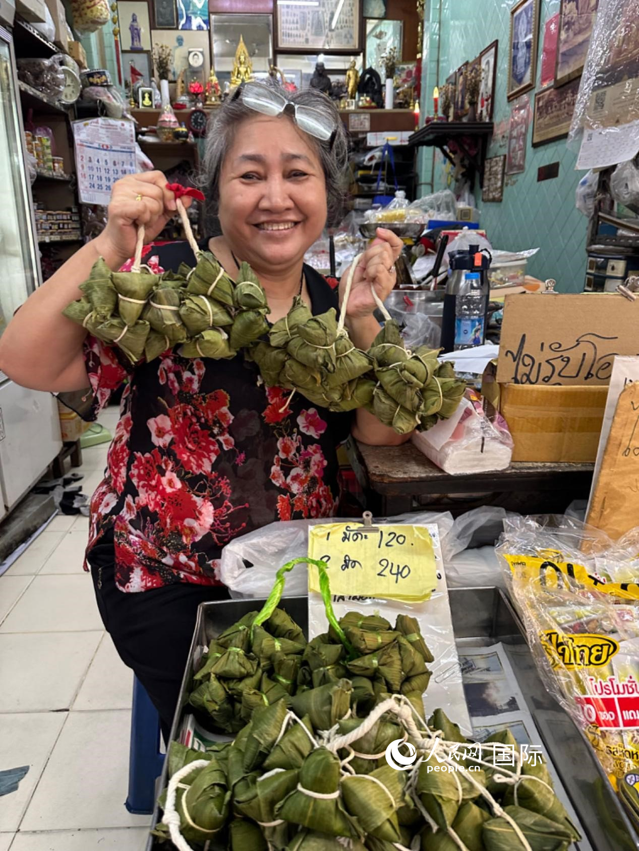 商家向顧客介紹“吉掌”（粽子的一種，一串一串，個(gè)頭較?。?。人民網(wǎng)記者 簡承淵攝
