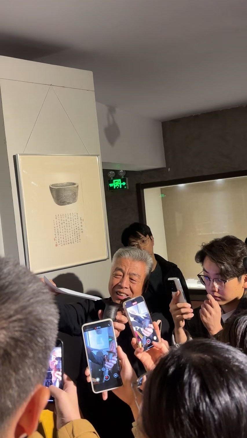 黑陶邢文化博物館館長邢葆東展示兩張相疊的A4紙，向記者解釋此為杯口的厚度。