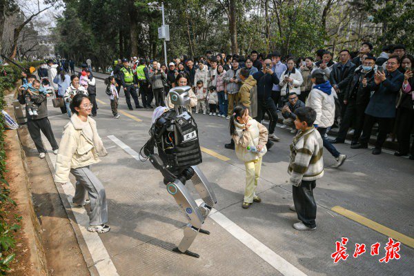 “智警小珞”人形機(jī)器人和小朋友們斗舞。長江日報(bào)記者史偉 攝