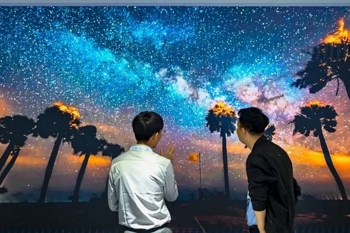 長春光博會(huì)希達(dá)電子展區(qū)，一位工作人員正在給一位觀眾講解。（長春新區(qū)供圖）